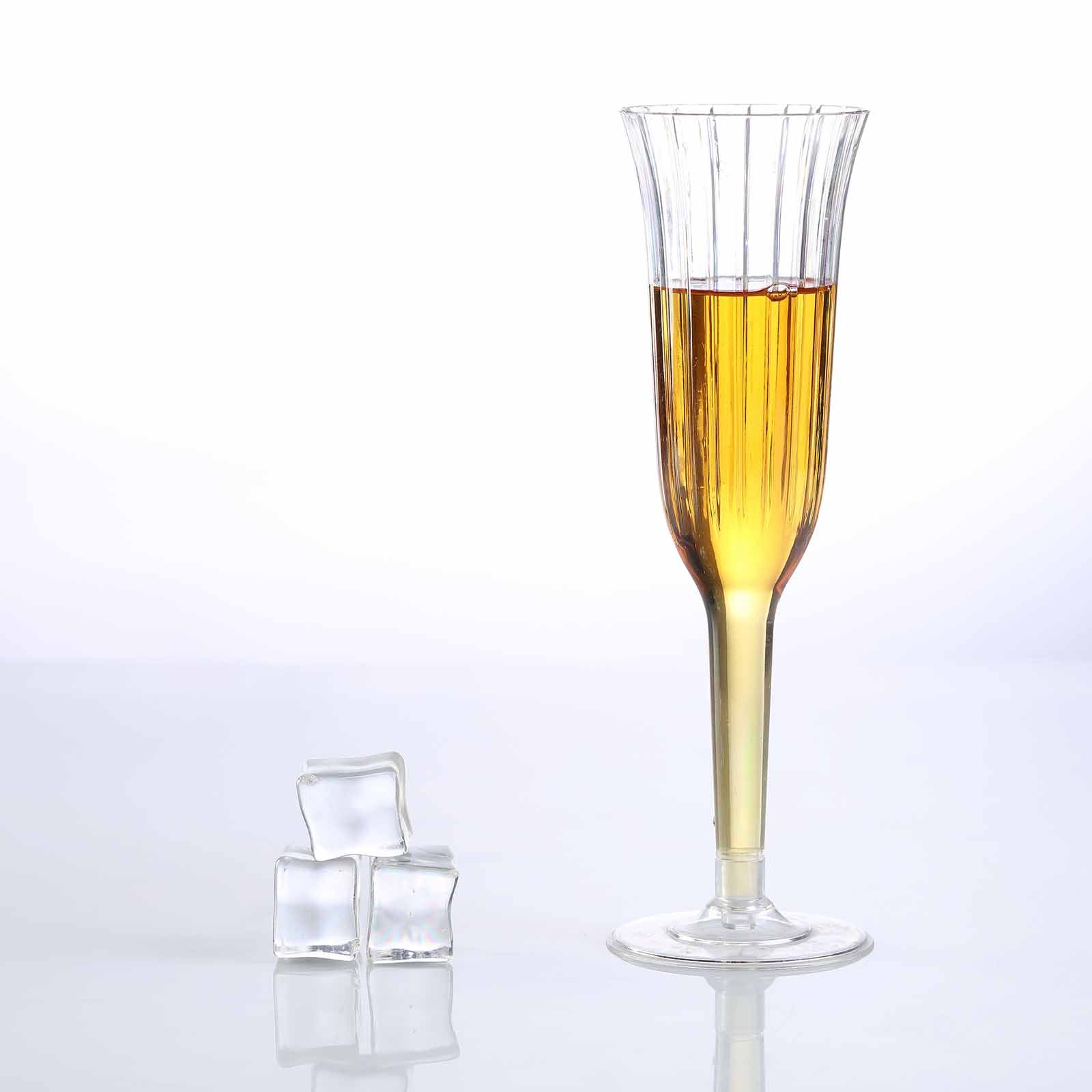 Clear flared plastic champagne flute with drink and ice cubes.