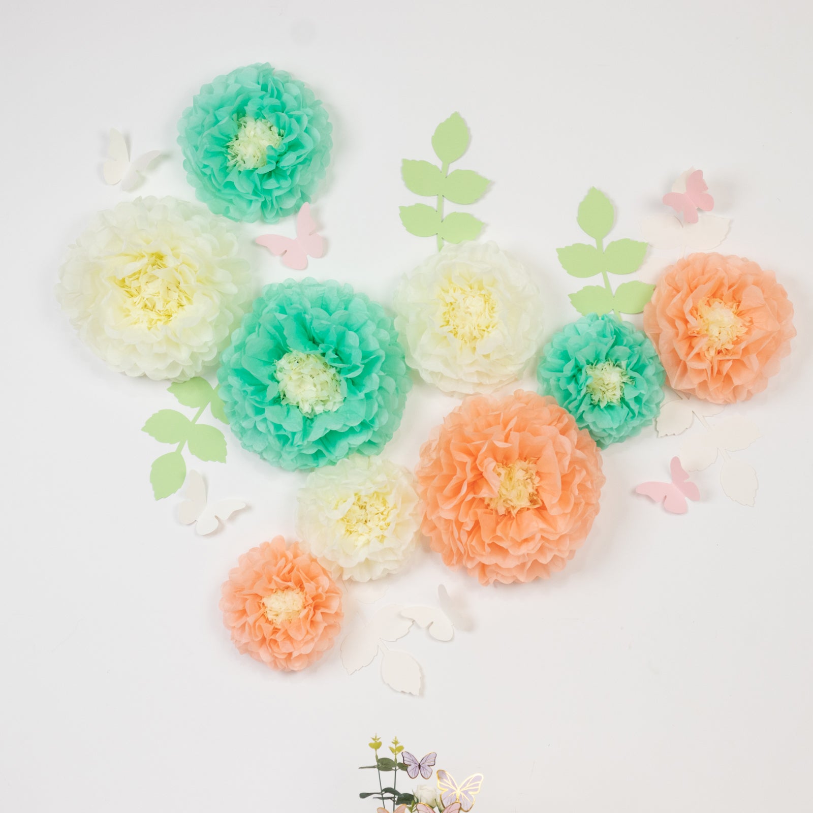 Cream and peach tissue paper pom poms with butterflies and olive leaves decor.
