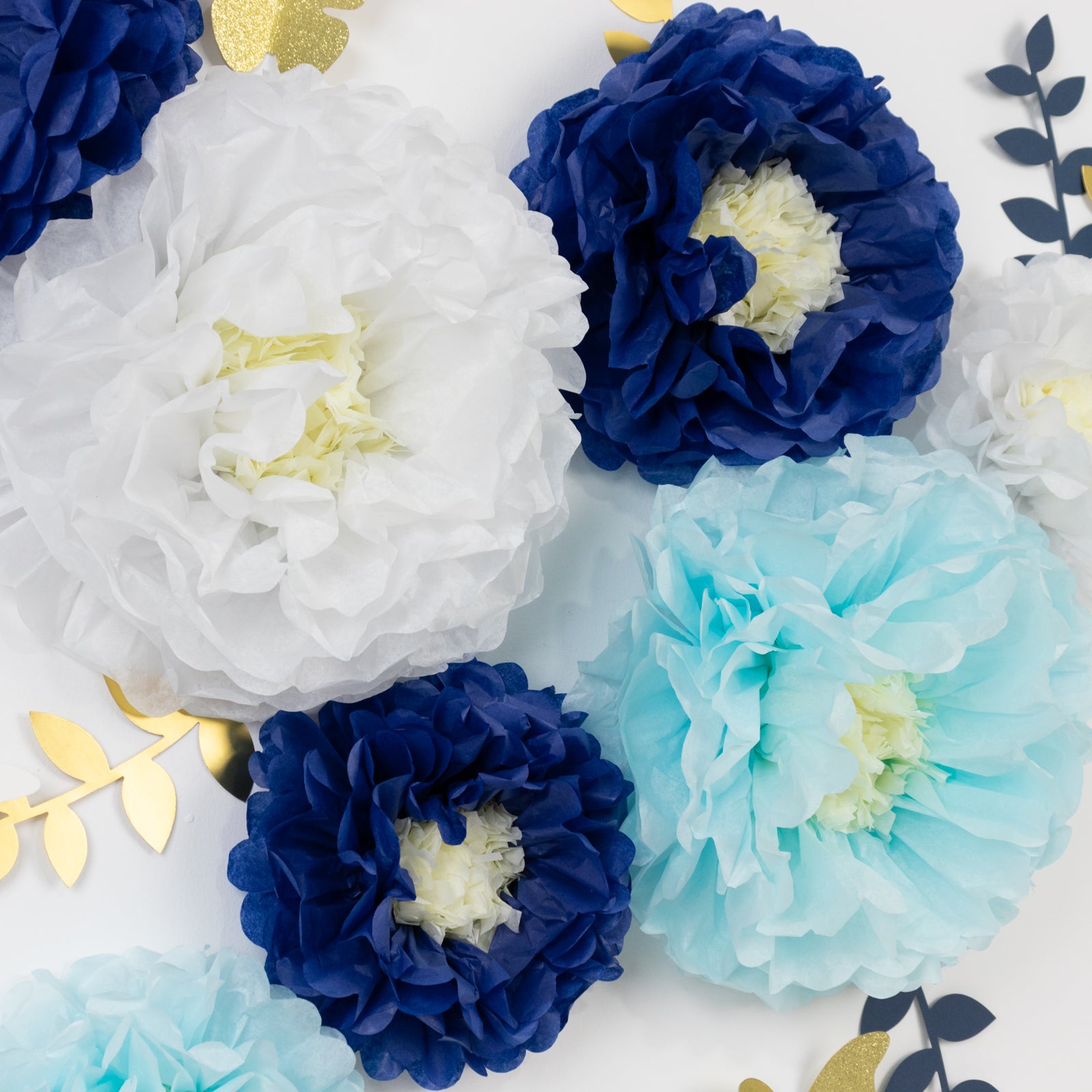Set of 21 white and blue tissue paper flowers with butterflies and olive leaves.