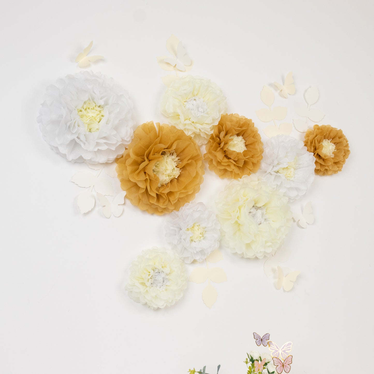 Set of tissue paper flowers in white and ivory with butterflies and leaves.
