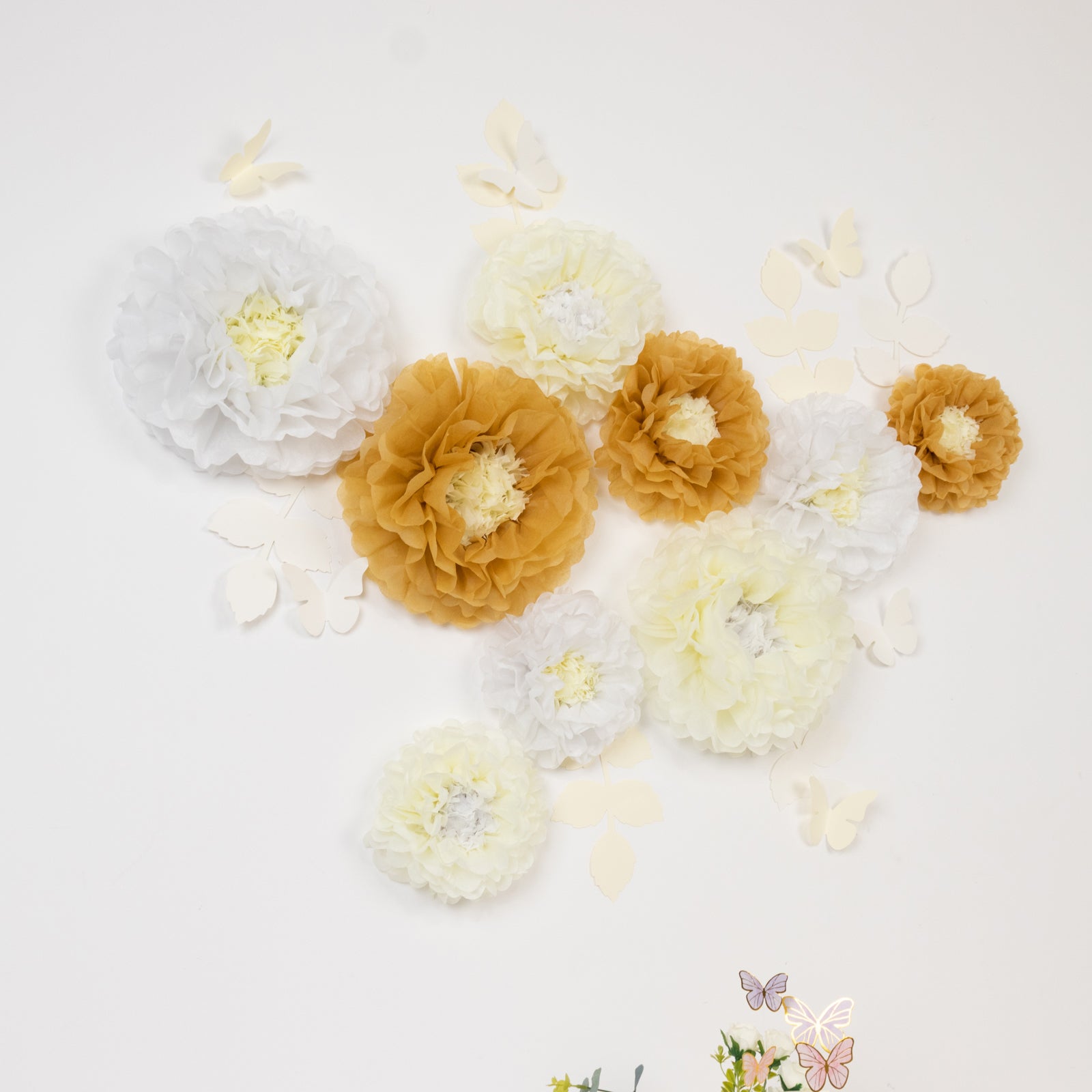 Set of tissue paper flowers in white and ivory with butterflies and leaves.