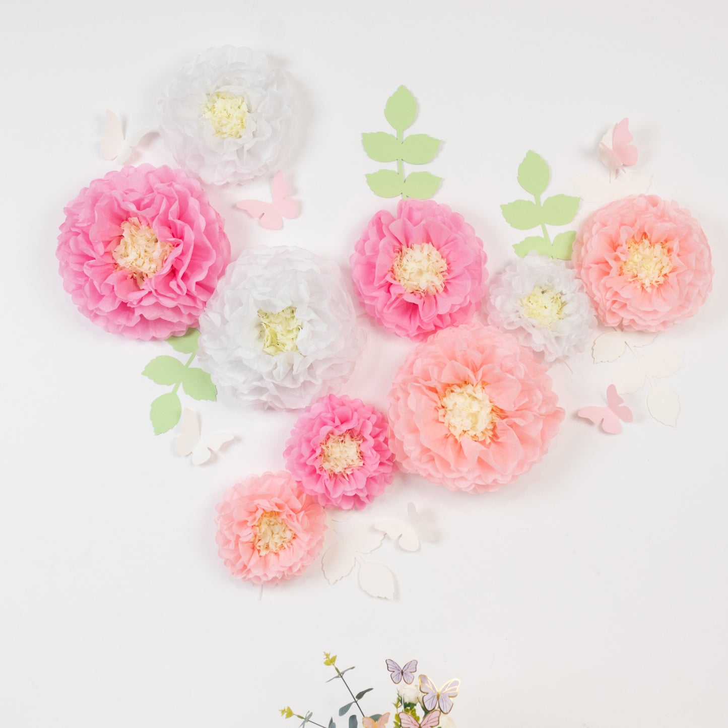Set of pink and white tissue paper flowers with butterflies and leaves.