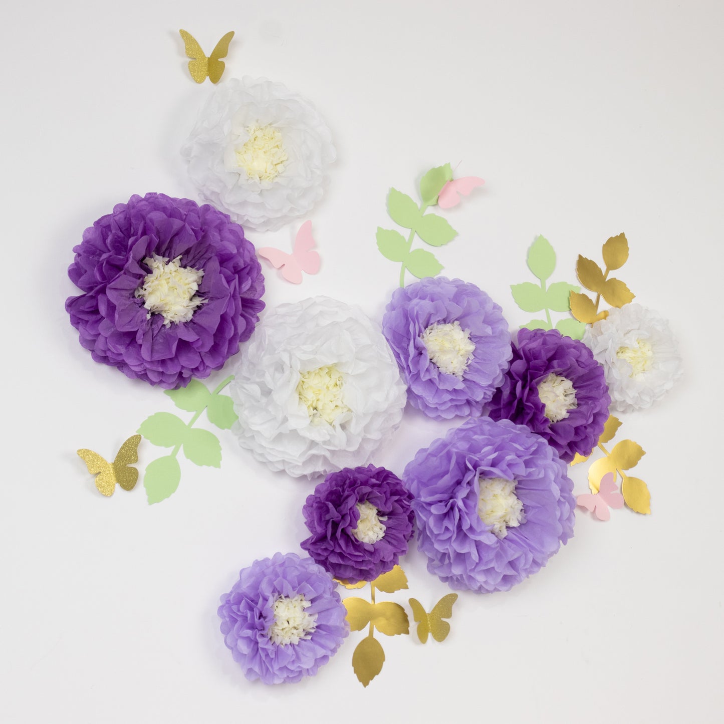 White and purple tissue paper pom poms with butterflies and leaves.
