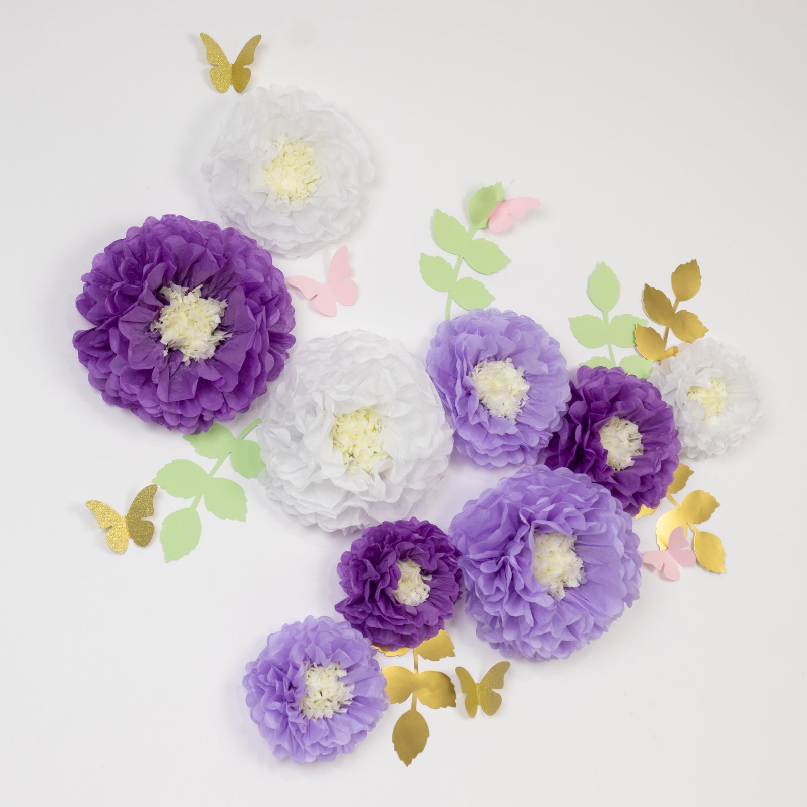 White and purple tissue paper pom poms with butterflies and leaves.