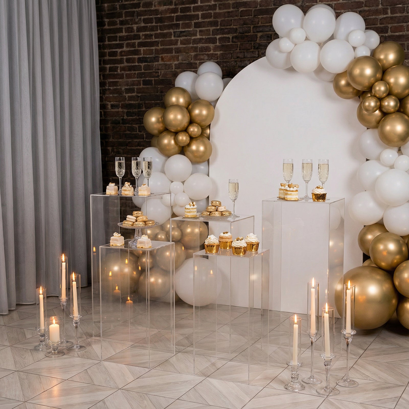 Clear acrylic pedestal stands for elegant event décor with gold and white accents.