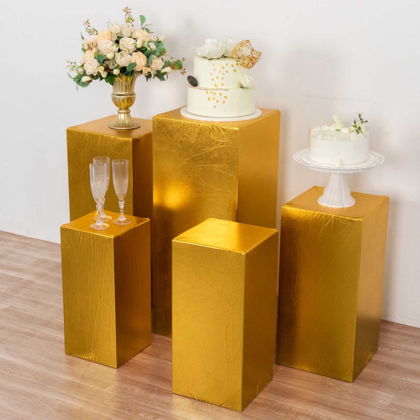 Metallic gold pedestal stand covers for elegant displays.