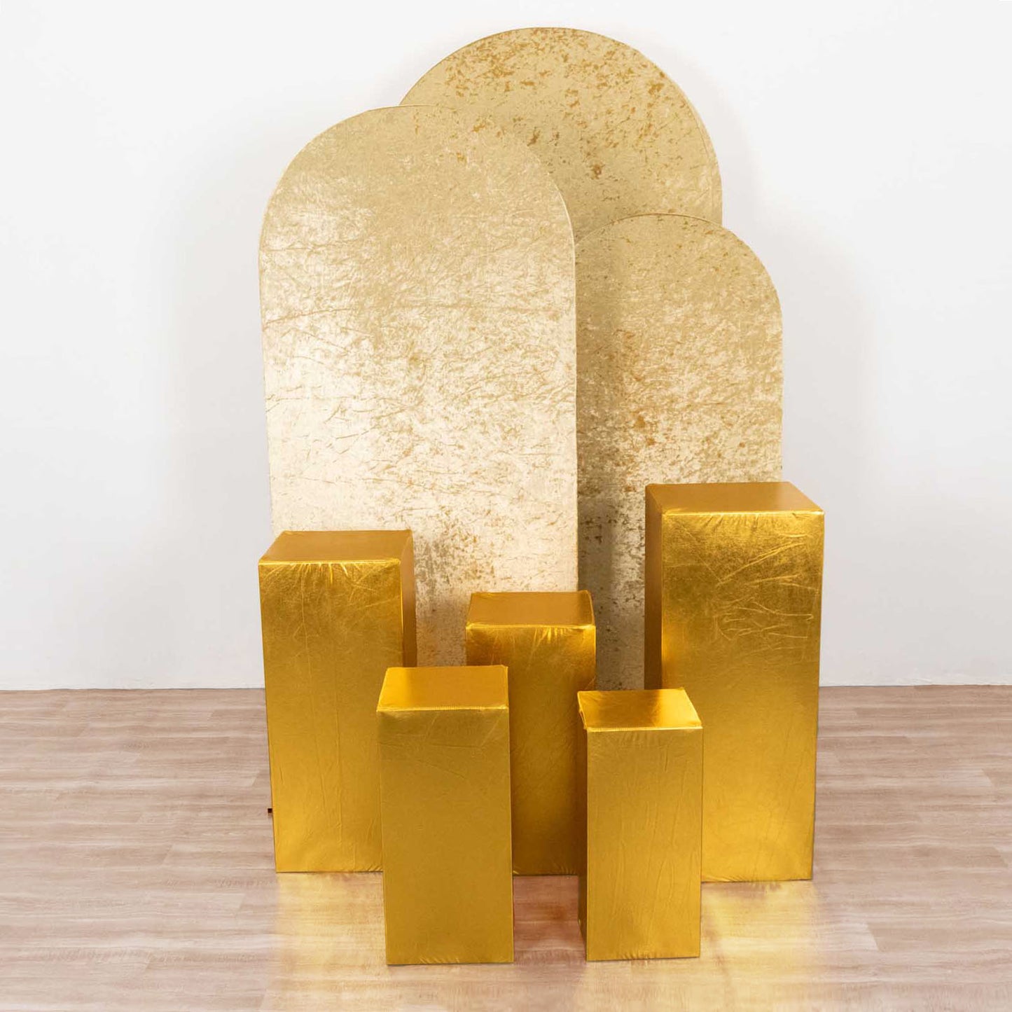 Metallic gold pedestal stand covers for event decoration.