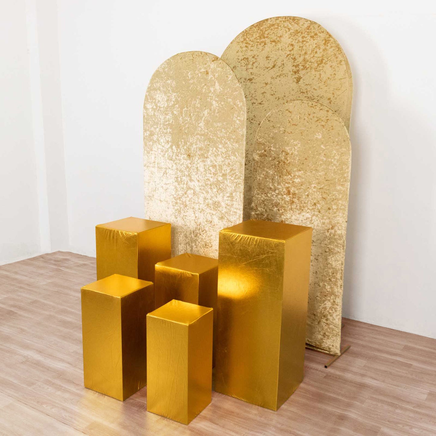 Metallic gold pedestal stand covers for events and displays.