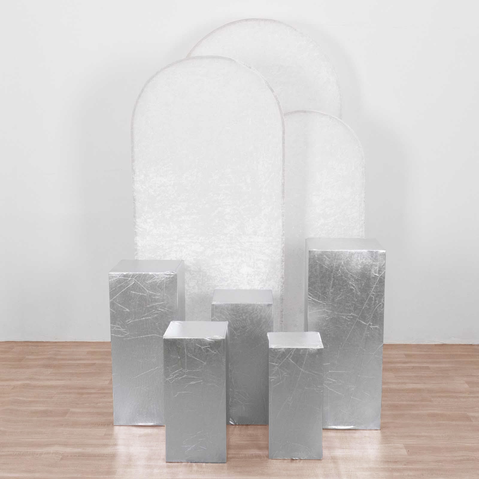 Metallic silver spandex pedestal stand covers for events and displays.