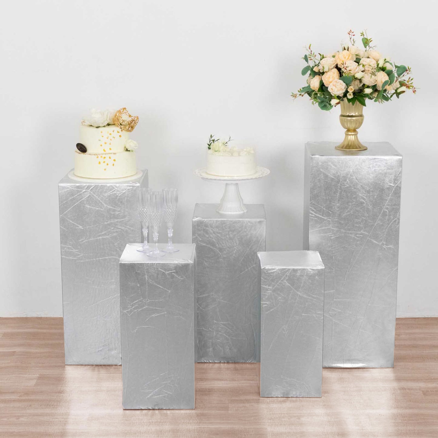 Set of 5 metallic silver spandex pedestal stand covers for events.
