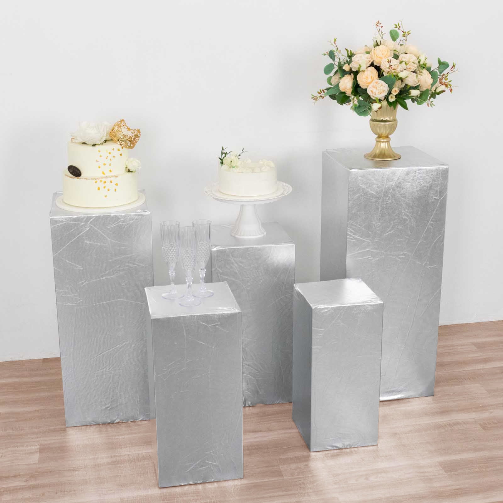Metallic silver stretchable pedestal stand covers on display with decorative elements.