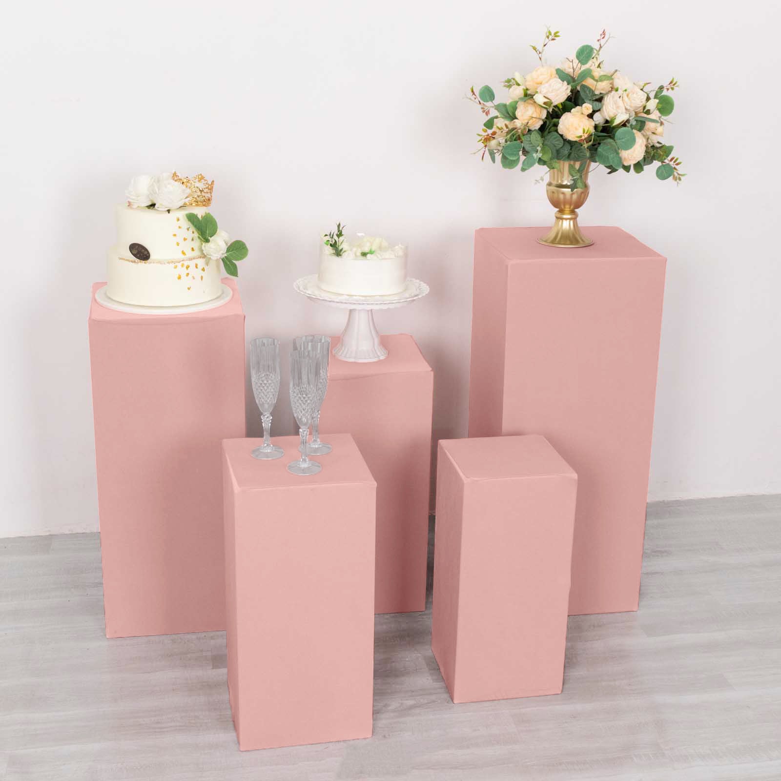 Dusty rose spandex pedestal stand covers for event displays.