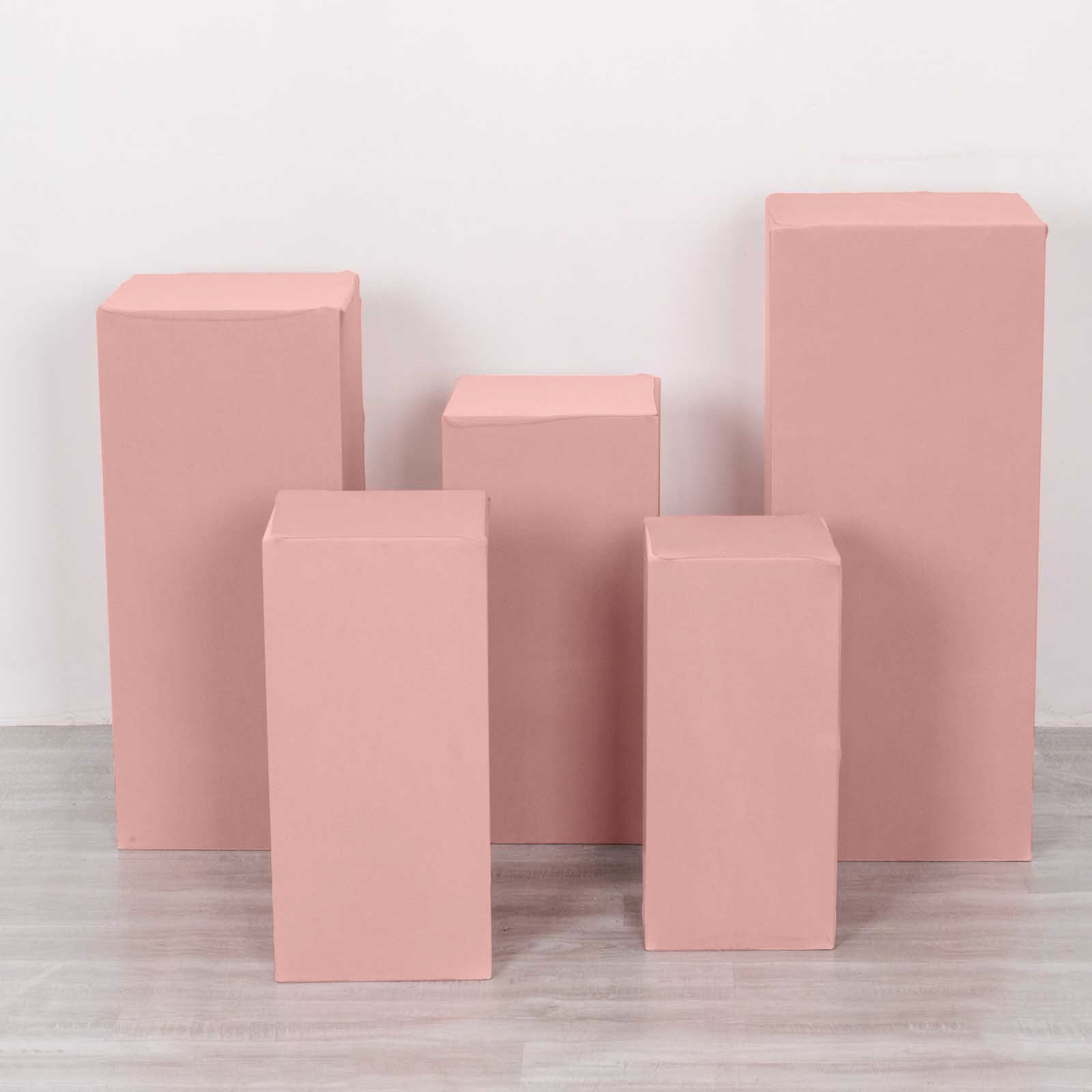 Dusty rose spandex pedestal stand covers in a set of five.