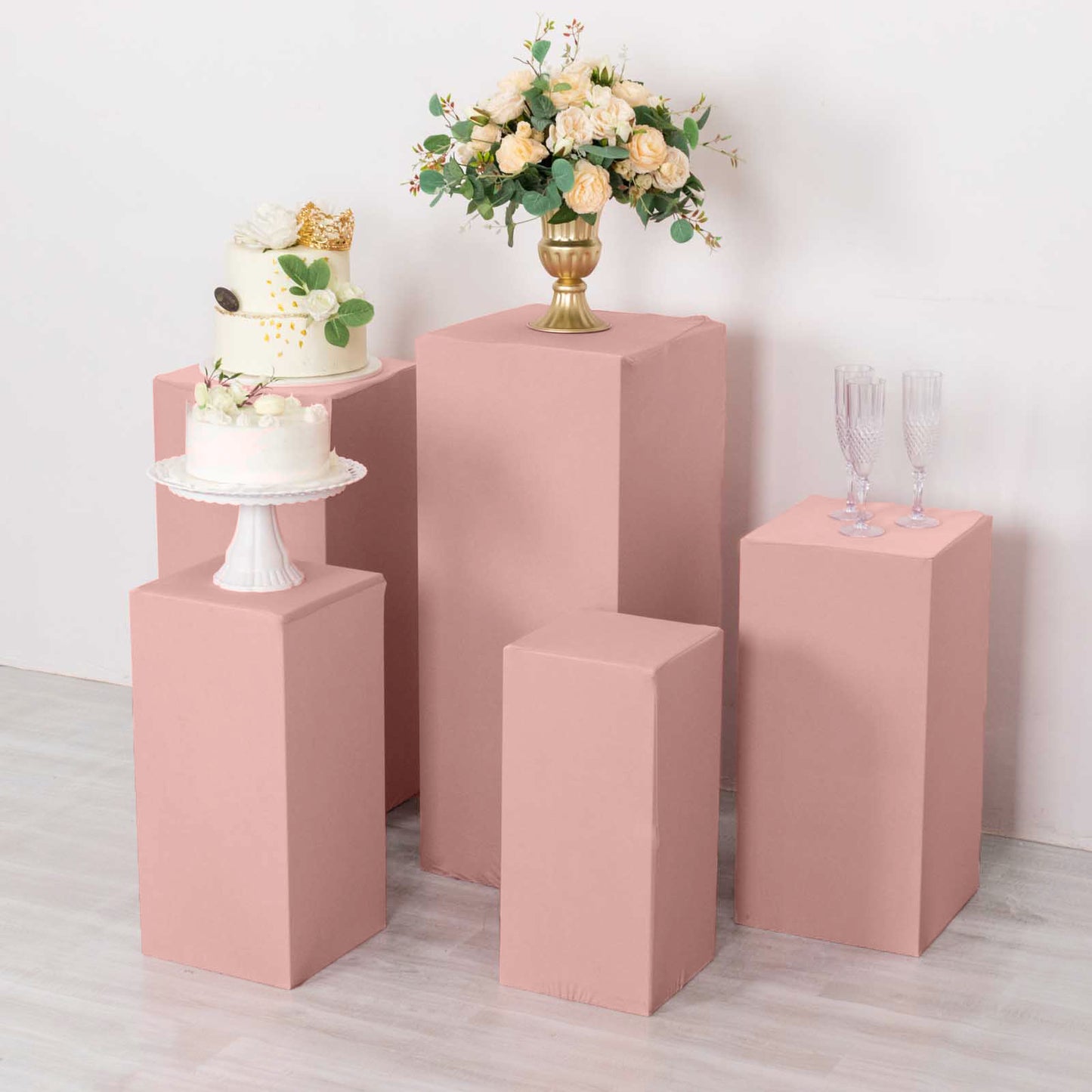Dusty rose spandex pedestal stand covers for events and displays.