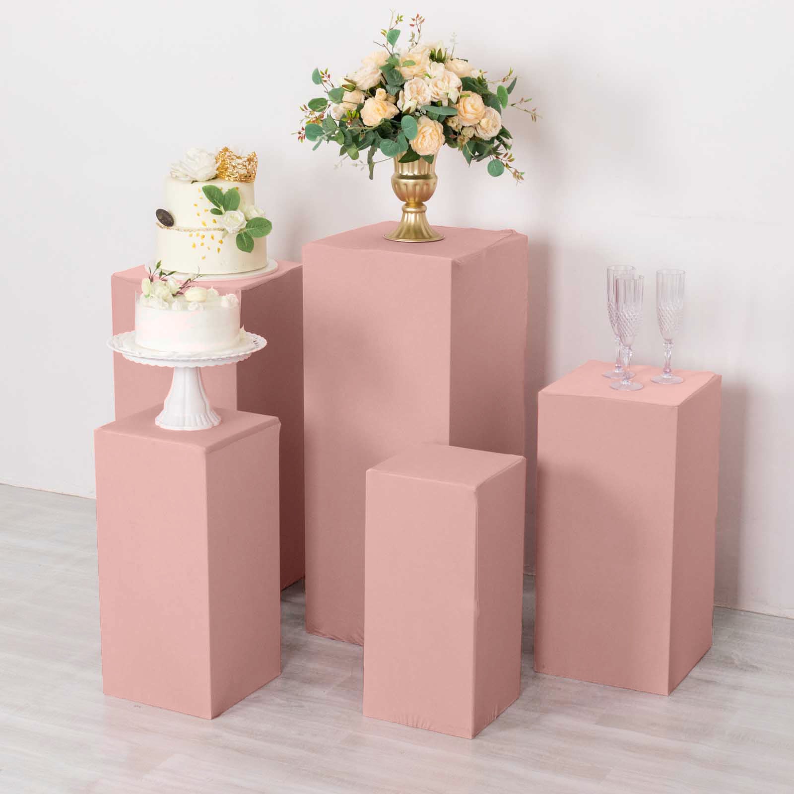 Dusty rose spandex pedestal stand covers for events and displays.