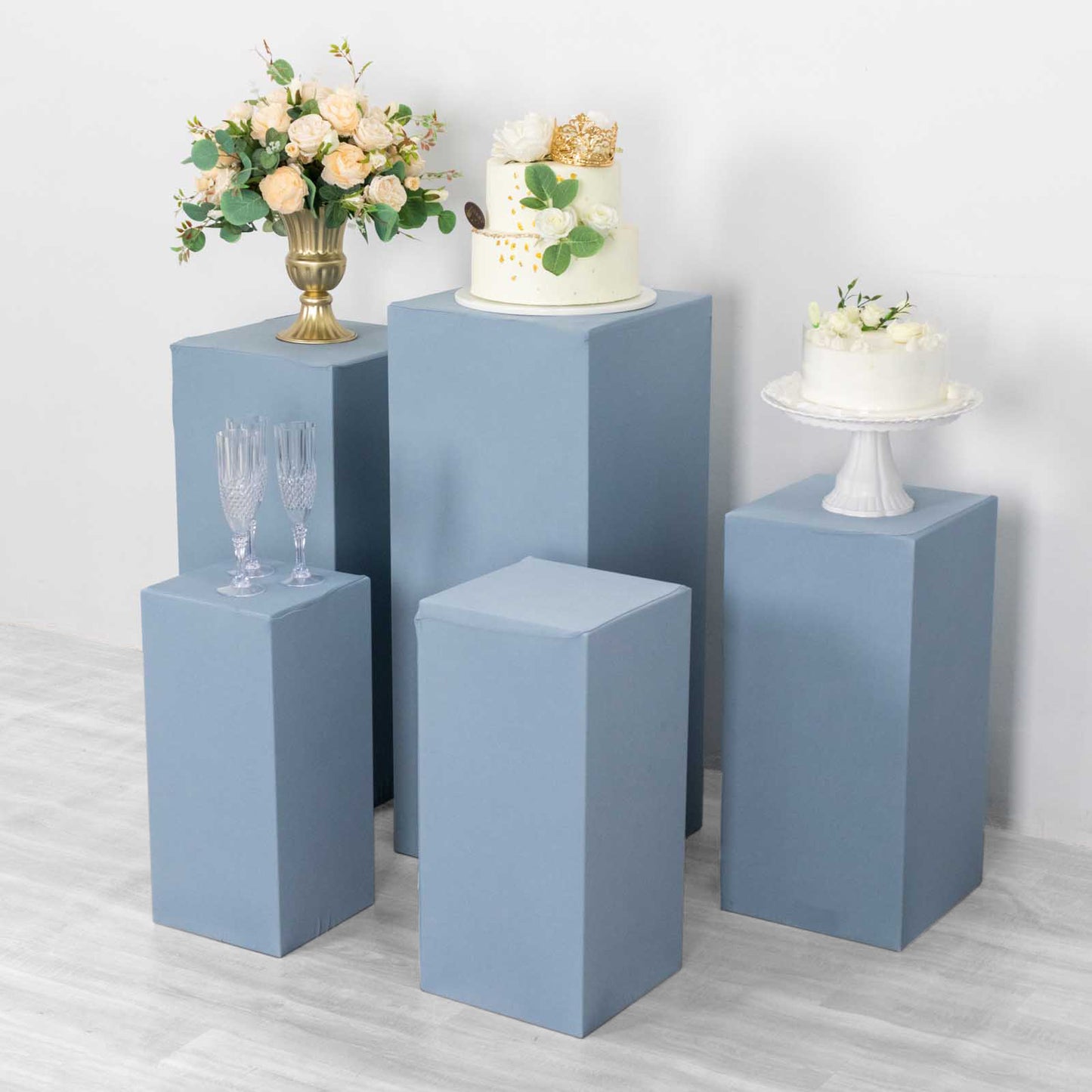 Dusty blue spandex pedestal stand covers for decorative displays.