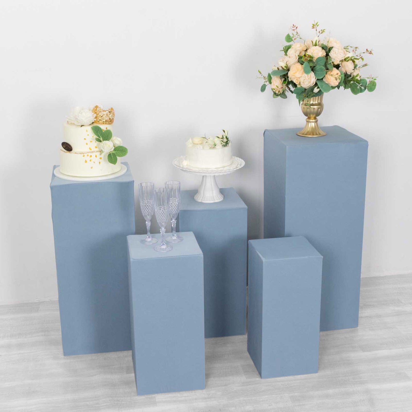 Dusty blue spandex pedestal stand covers for event displays.
