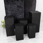 Set of 5 black spandex pedestal stand covers for events.