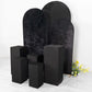 Set of 5 black spandex pedestal stand covers for events.