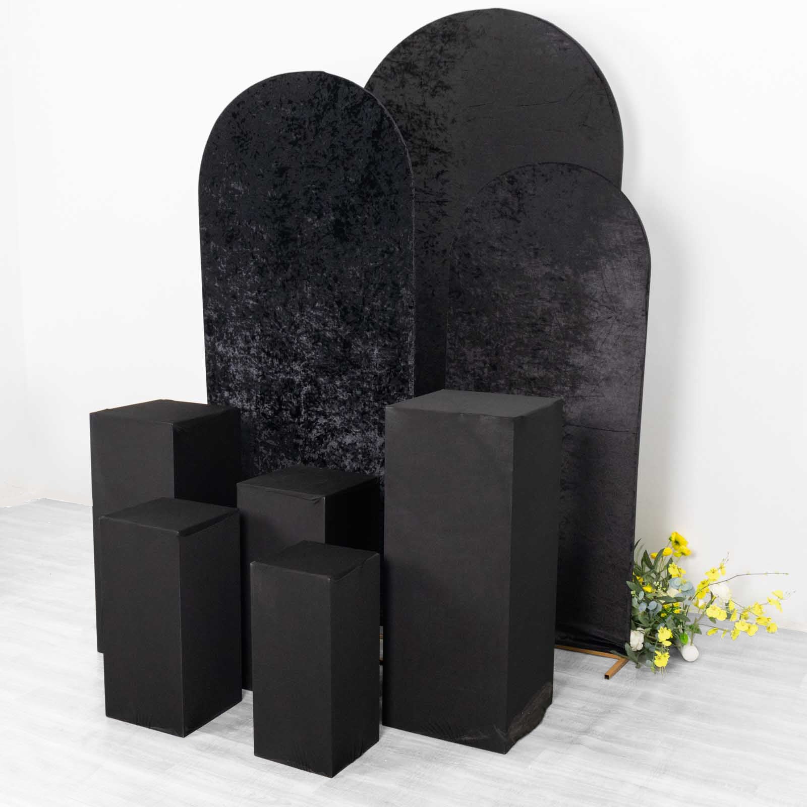 Set of 5 black spandex pedestal stand covers for events.