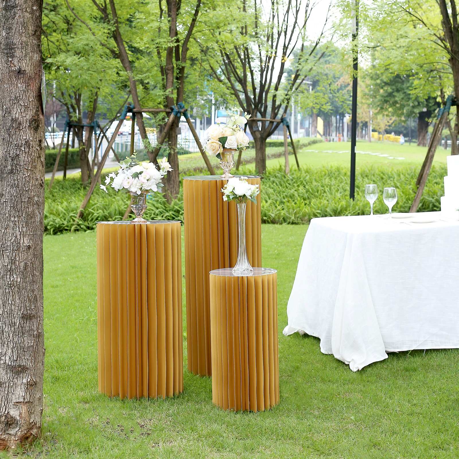 24" gold cylinder display column stand with top plate in an outdoor setting.