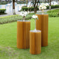 Gold cylinder display column stand, pillar pedestal with top plate in outdoor setting.