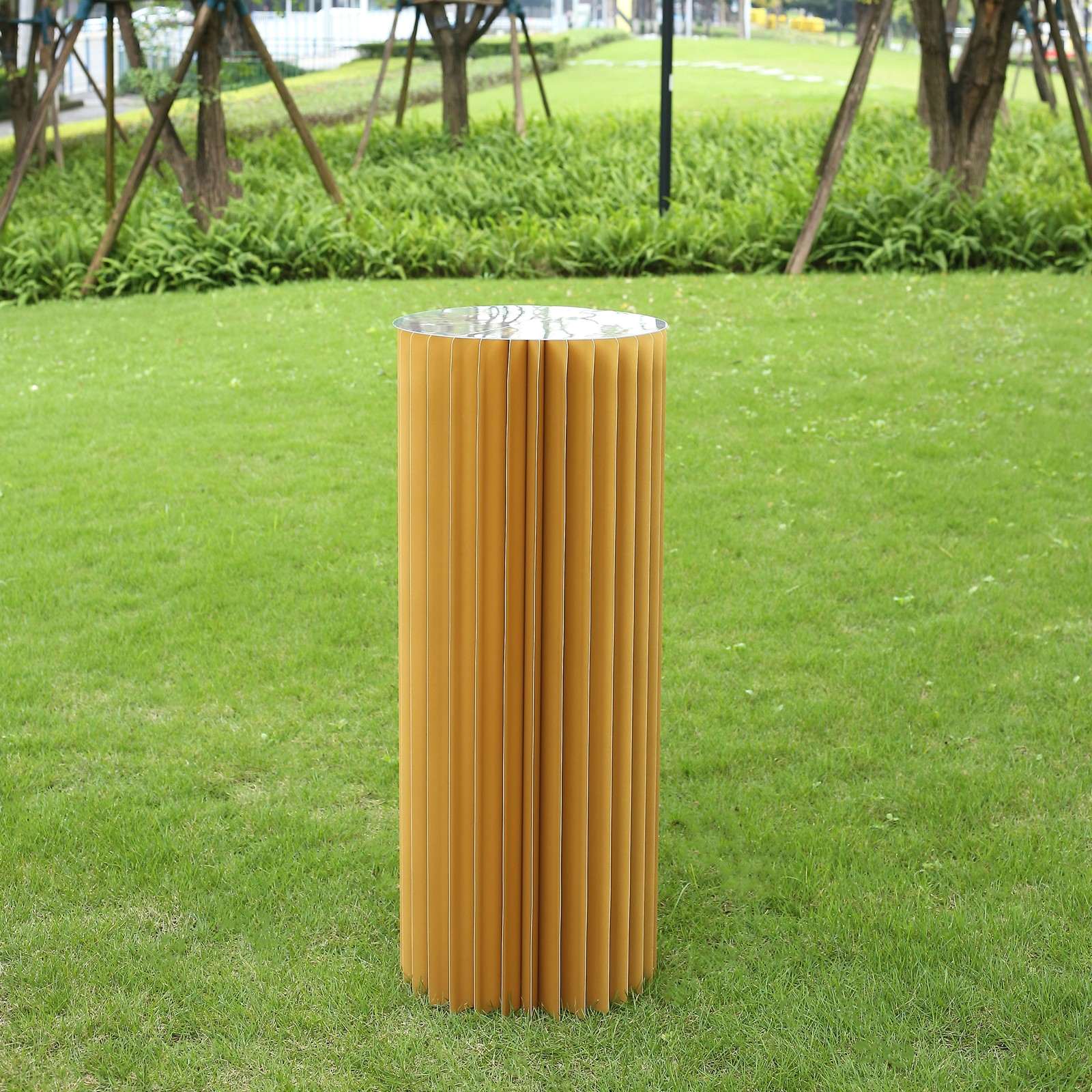 Golden cylinder display column stand with a top plate.