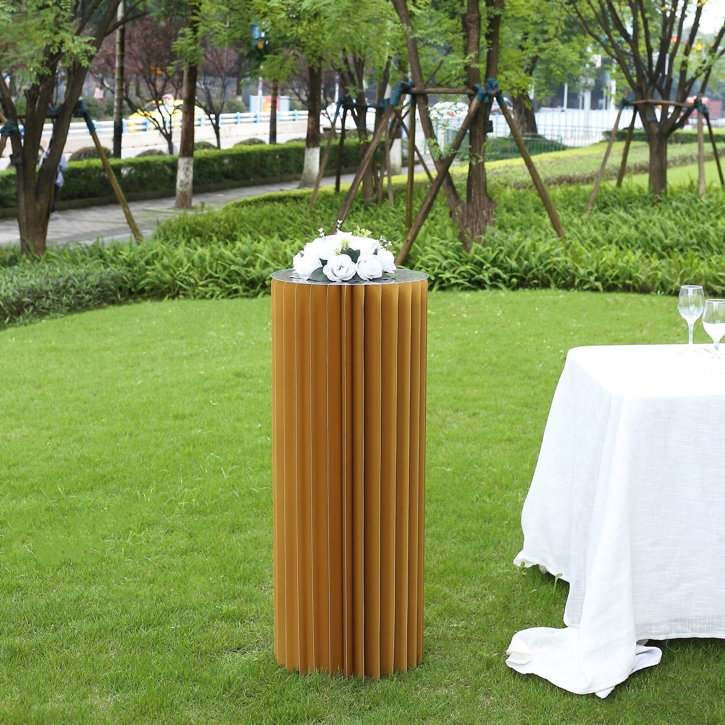 40" gold cylinder display column stand with top plate in an outdoor setting.
