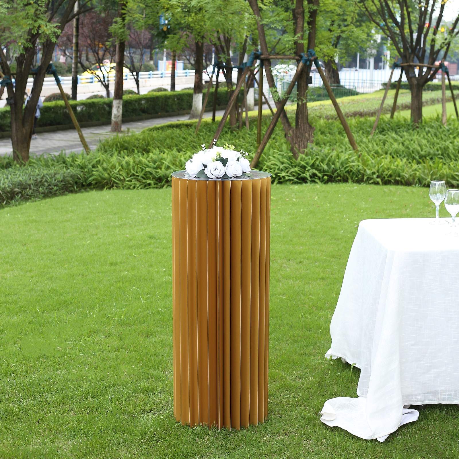 40" gold cylinder display column stand with top plate in an outdoor setting.
