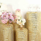 Gold sequin mesh pedestal stand covers with geometric pattern embroidery.