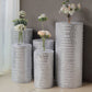Silver sequin mesh pedestal stand covers with geometric pattern and floral arrangements.