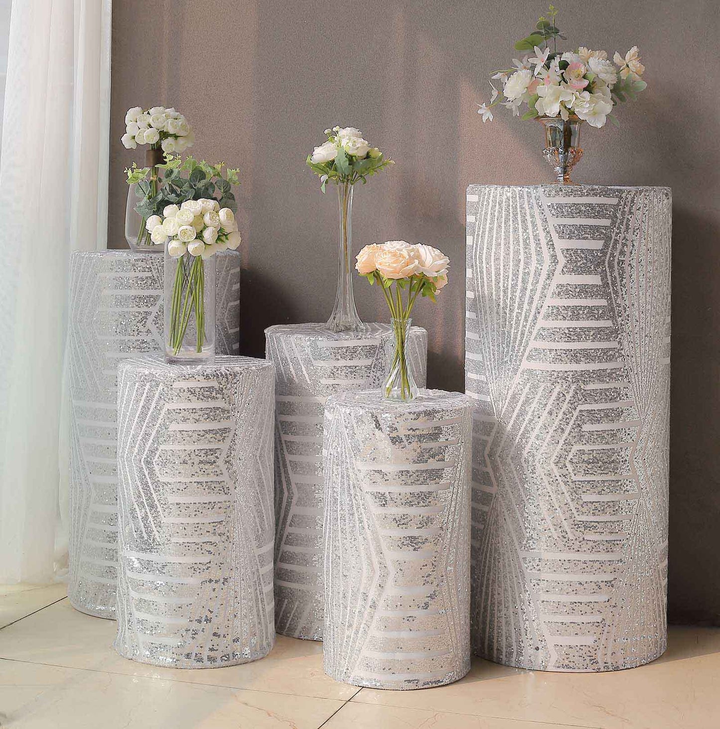 Silver sequin cylinder pedestal stand covers with geometric pattern.