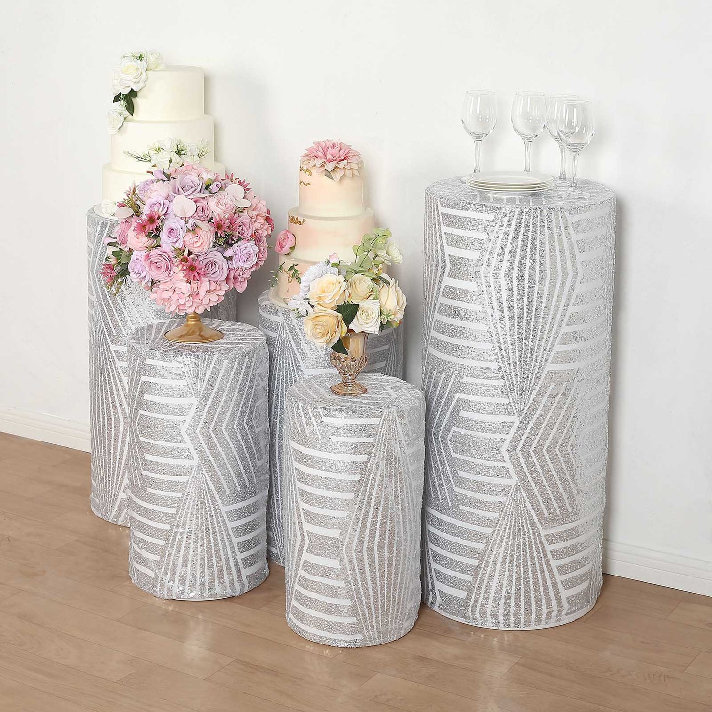 Silver sequin mesh pedestal stand covers with geometric embroidery.