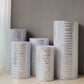 Set of 5 silver sequin mesh cylinder pedestal stand covers with geometric pattern.