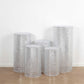 Set of 5 silver sequin mesh pedestal stand covers with geometric embroidery.