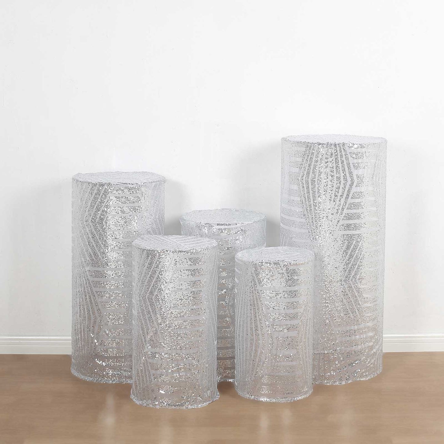 Set of 5 silver sequin mesh pedestal stand covers with geometric embroidery.
