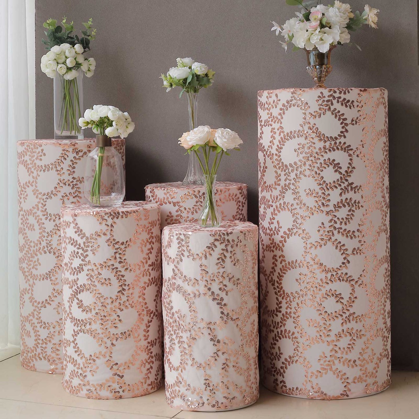 Rose gold sequin pedestal stand covers with leaf vine embroidery.