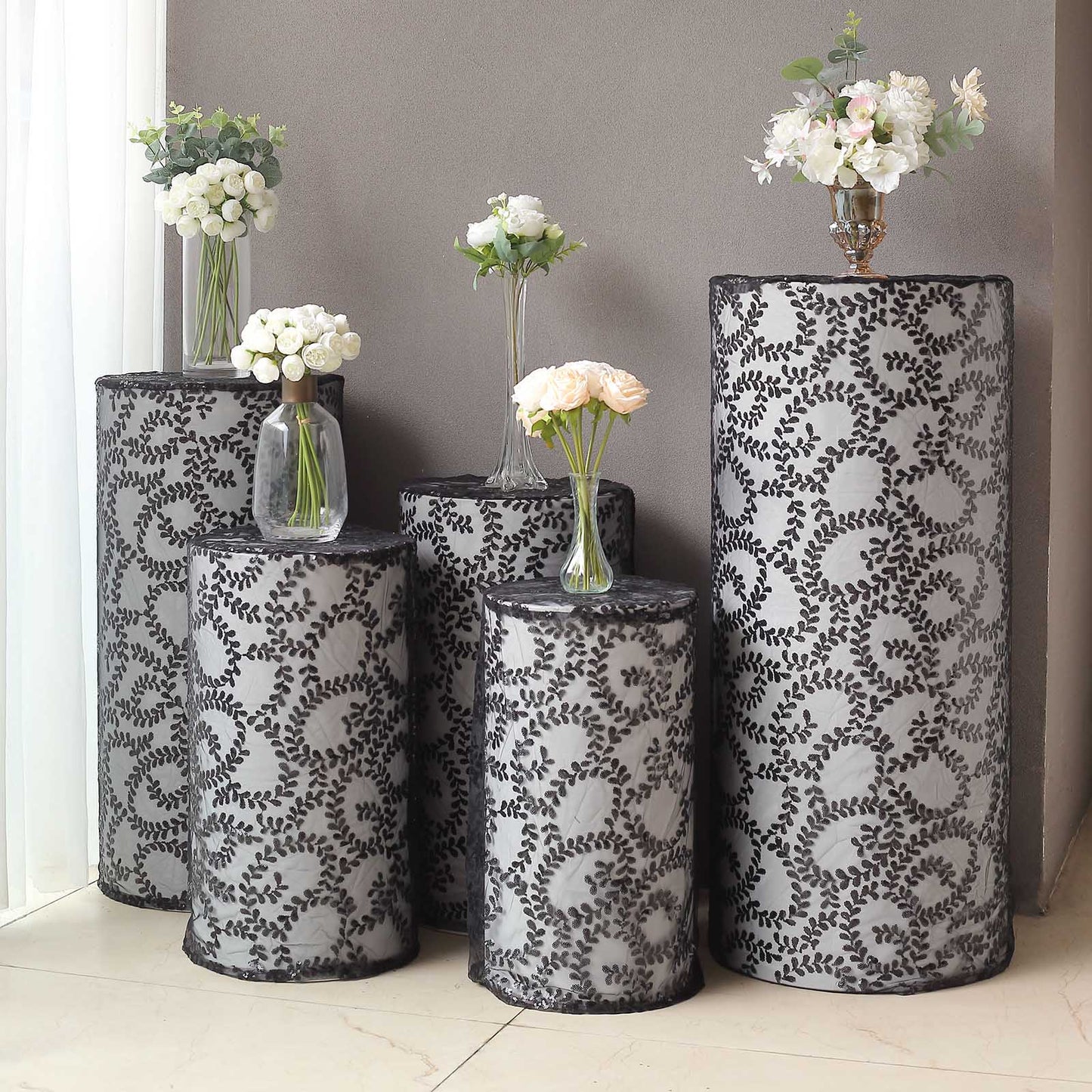 Set of 5 black sequin mesh cylinder pedestal stand covers with leaf vine embroidery.