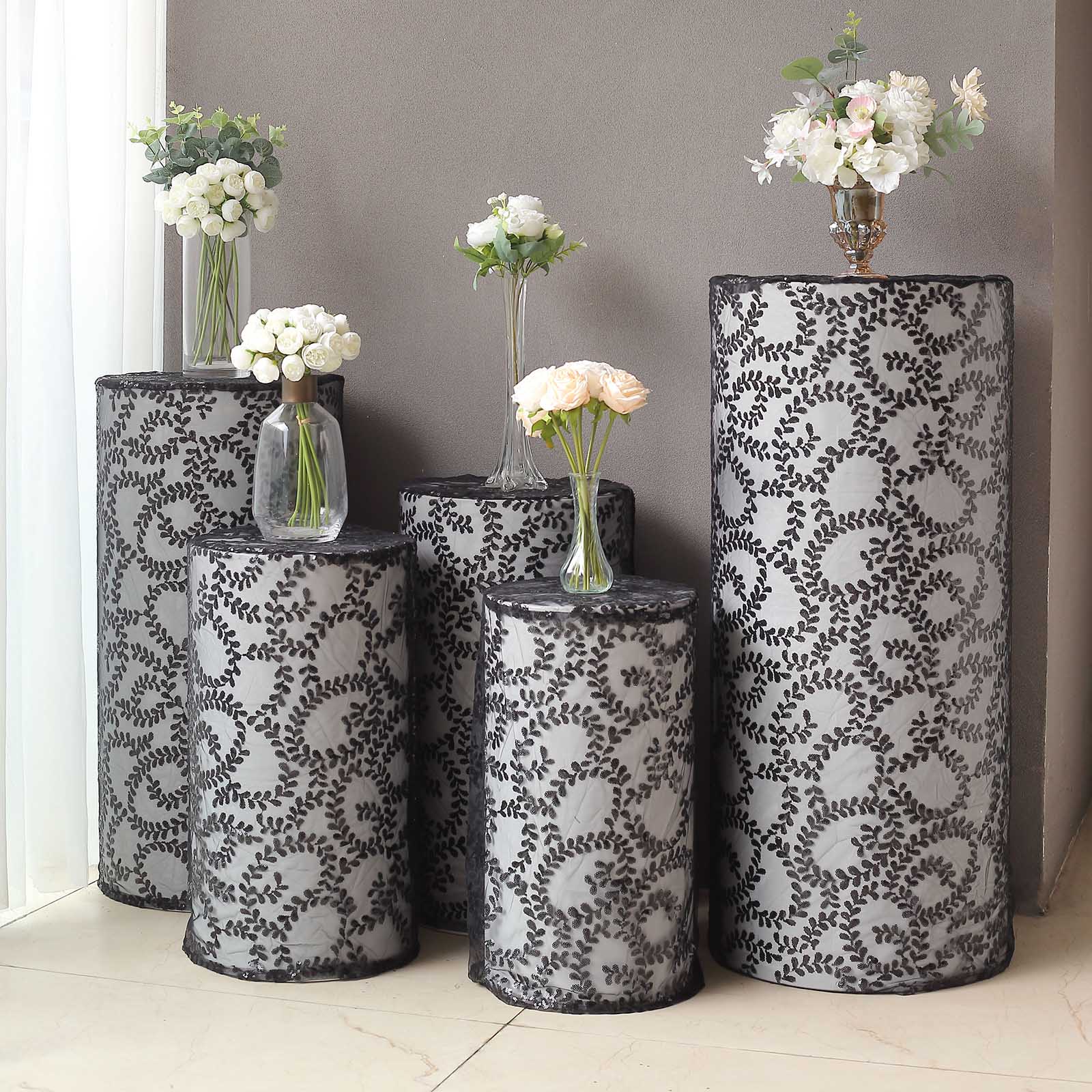 Set of 5 black sequin mesh cylinder pedestal stand covers with leaf vine embroidery.