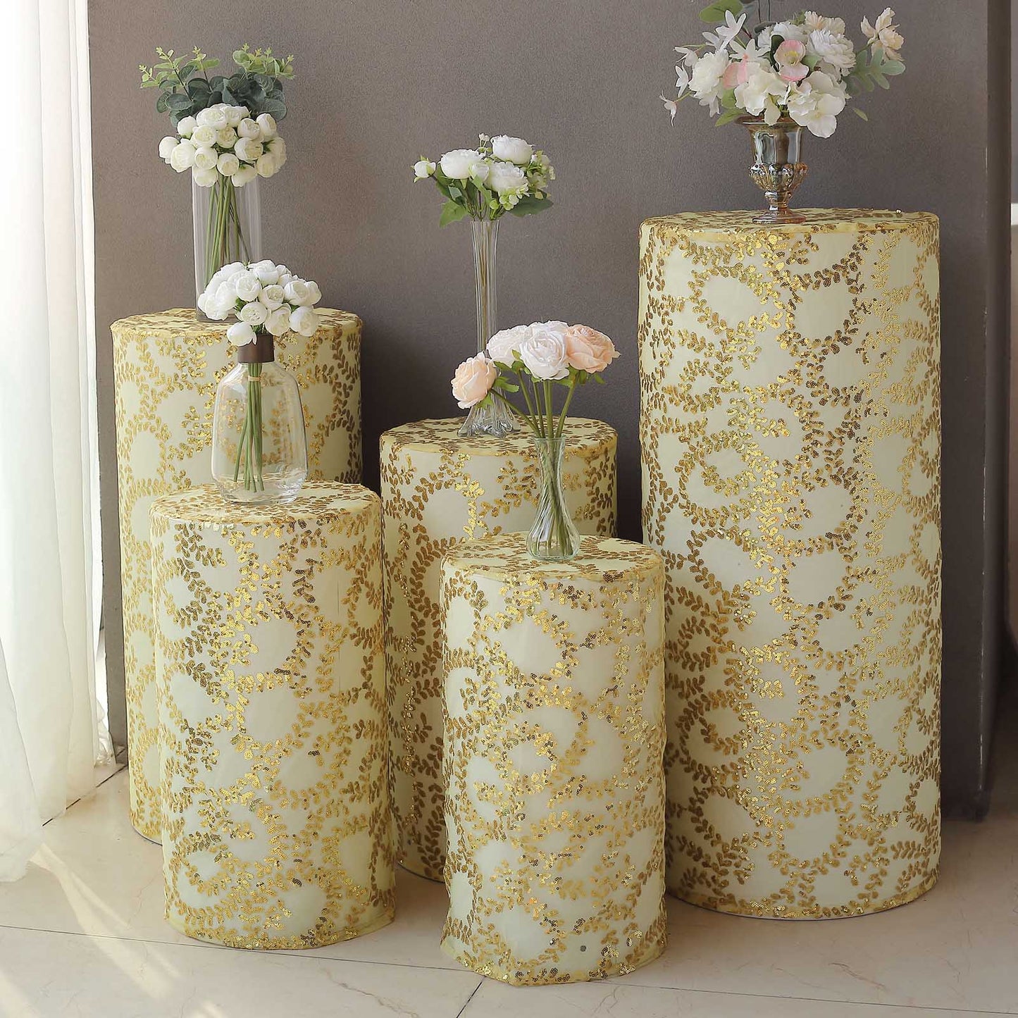 Gold sequin mesh pedestal stand covers with leaf vine embroidery.