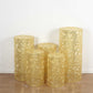 Gold sequin mesh cylinder pedestal stand covers with leaf vine embroidery.