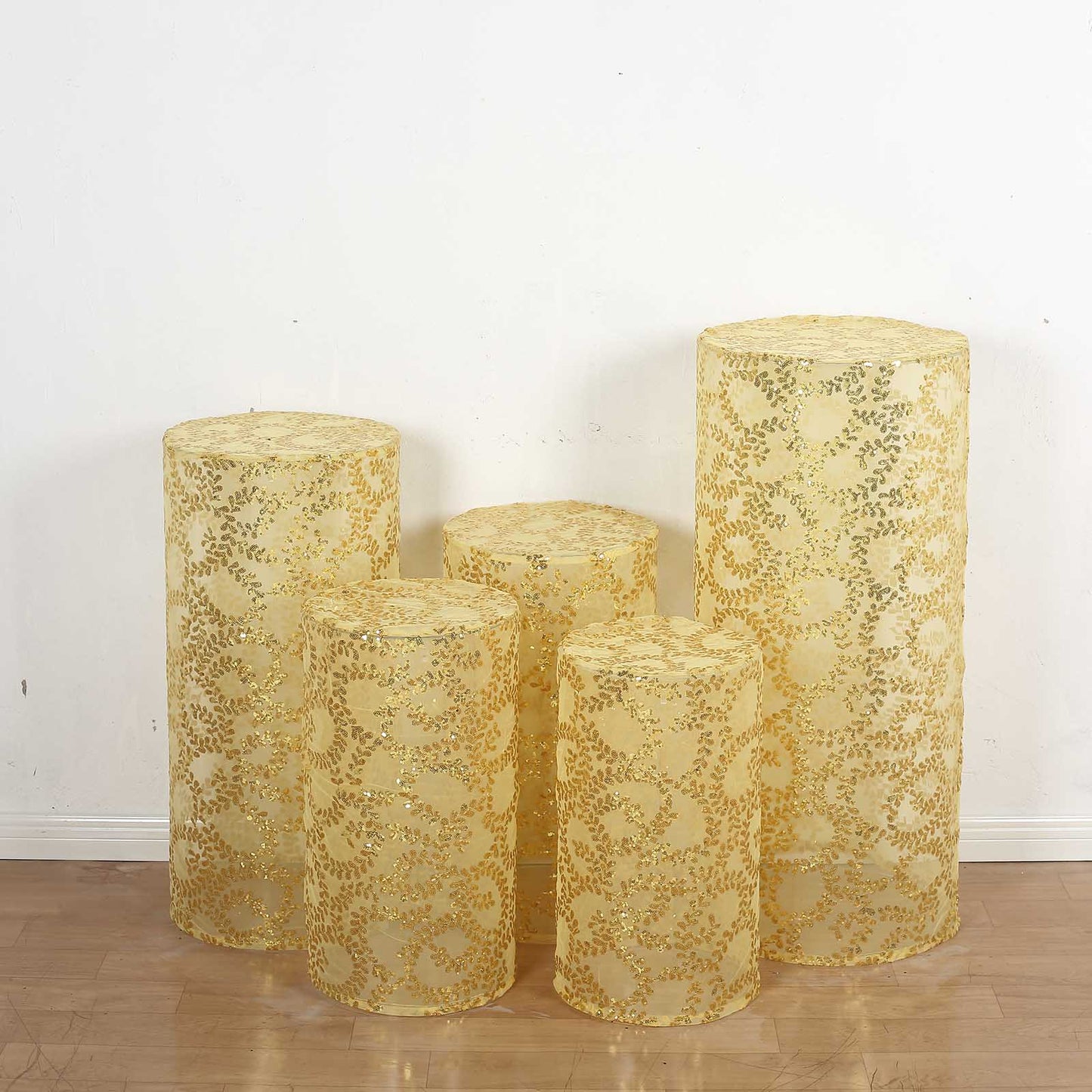 Gold sequin mesh cylinder pedestal stand covers with leaf vine embroidery.