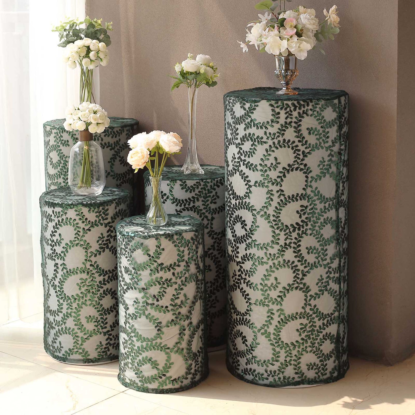 Emerald green sequin mesh pedestal stand covers with leaf vine embroidery.