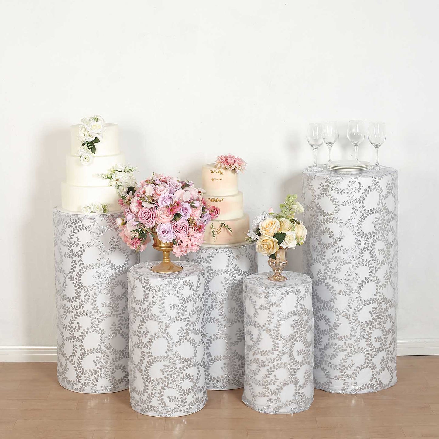 Silver sequin mesh pedestal stand covers with leaf vine embroidery.