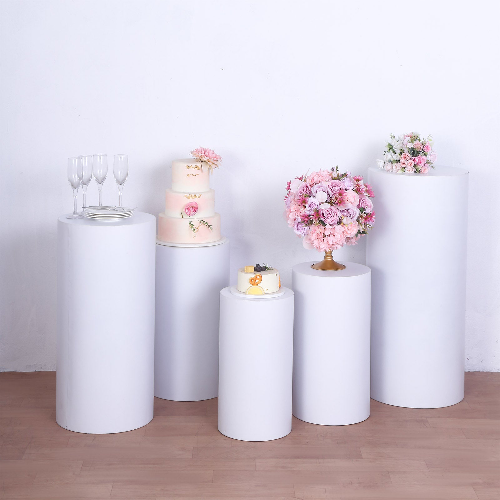 White metal cylinder pillar stands for wedding displays.