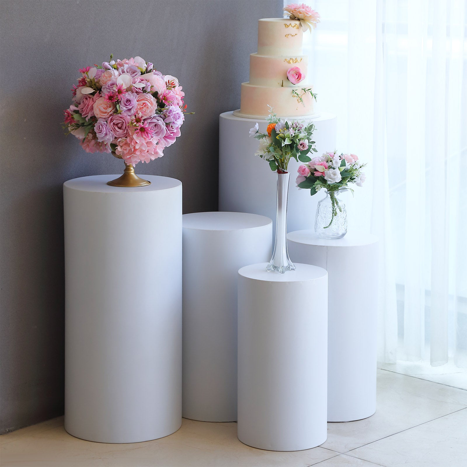 White metal cylinder pillar stands for wedding display, various heights.