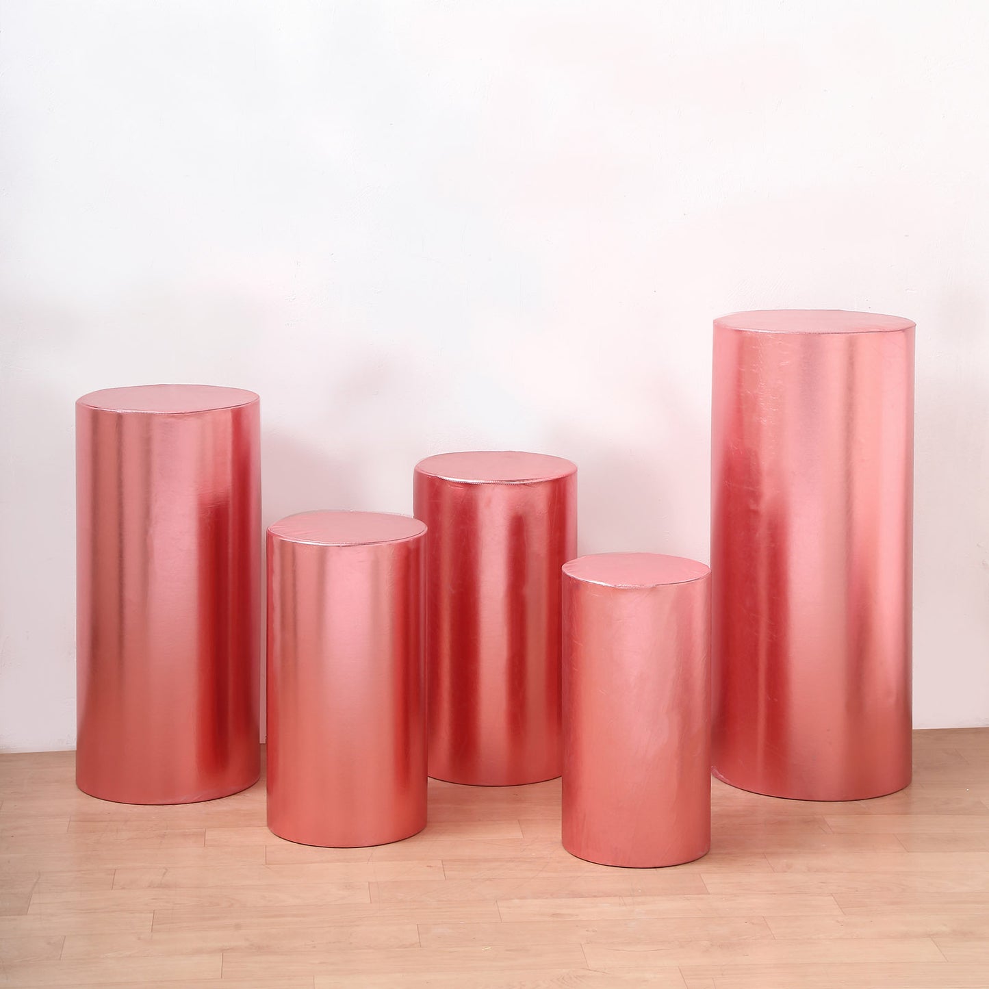 Metallic rose gold spandex pedestal stand covers in various sizes.