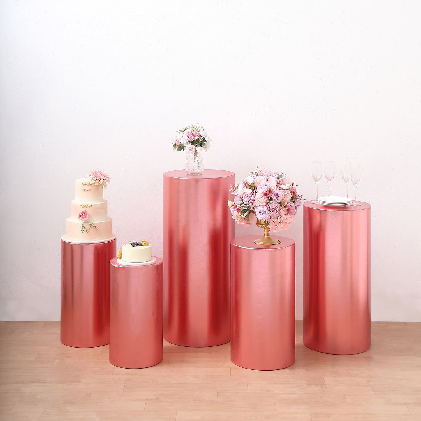 Metallic rose gold pedestal stand covers for events and displays.