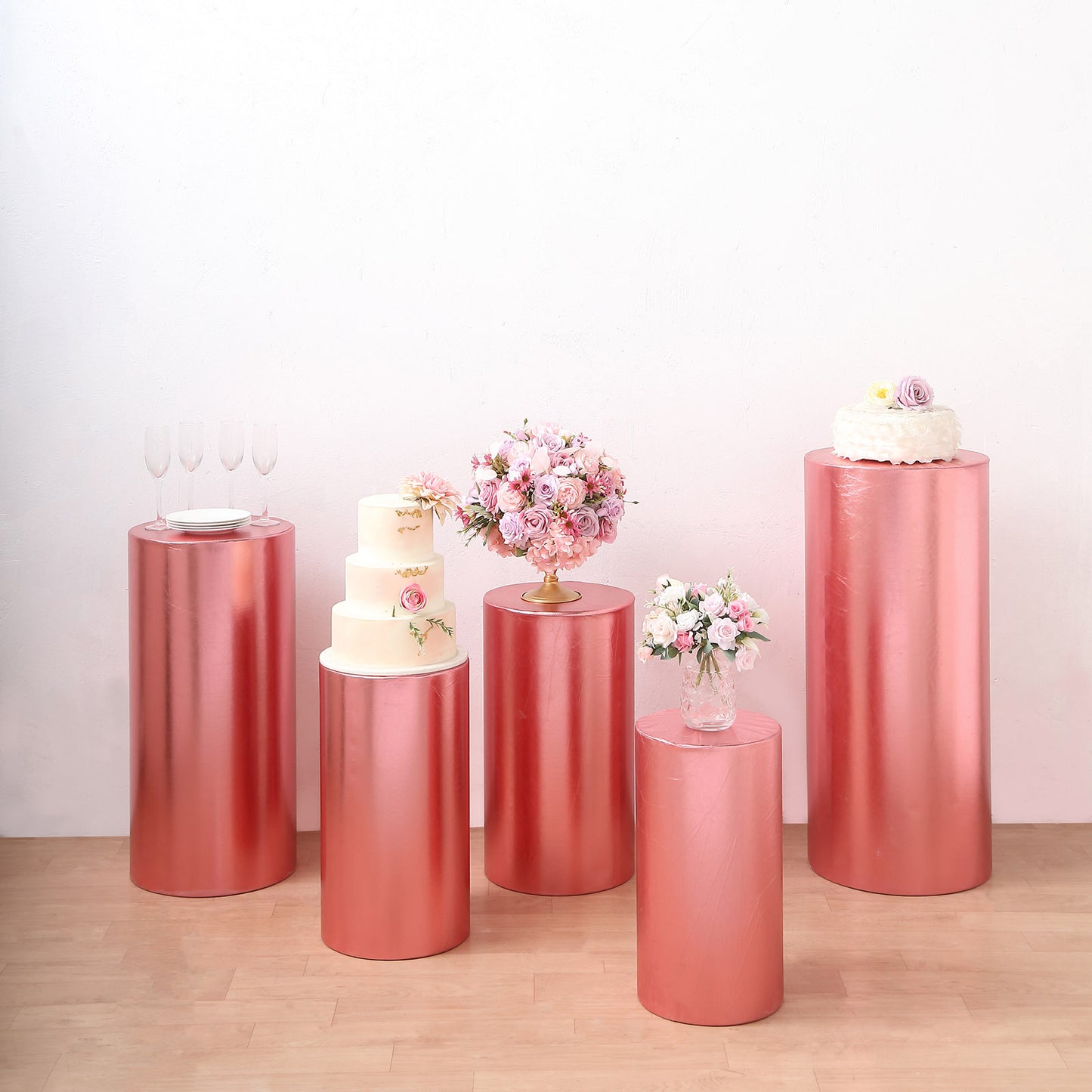 Metallic rose gold pedestal stand covers for events and displays.