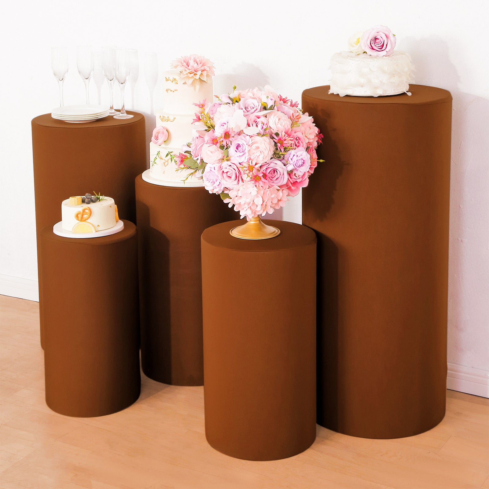 Cinnamon brown spandex pedestal stand covers displayed with decorative items.